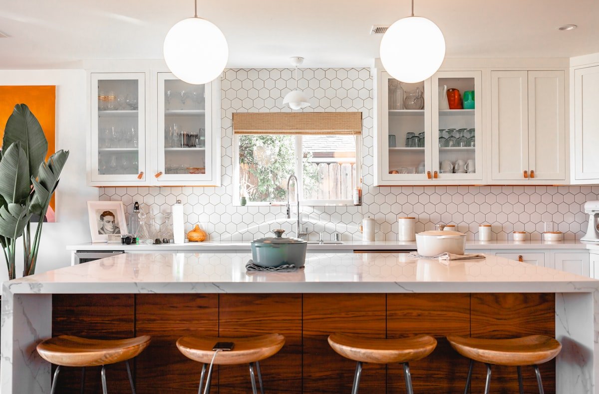 Renovated kitchen with white cabinets, wood island and pendant lighting